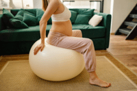 Pregnant woman sitting on birthing ball preparing for labor