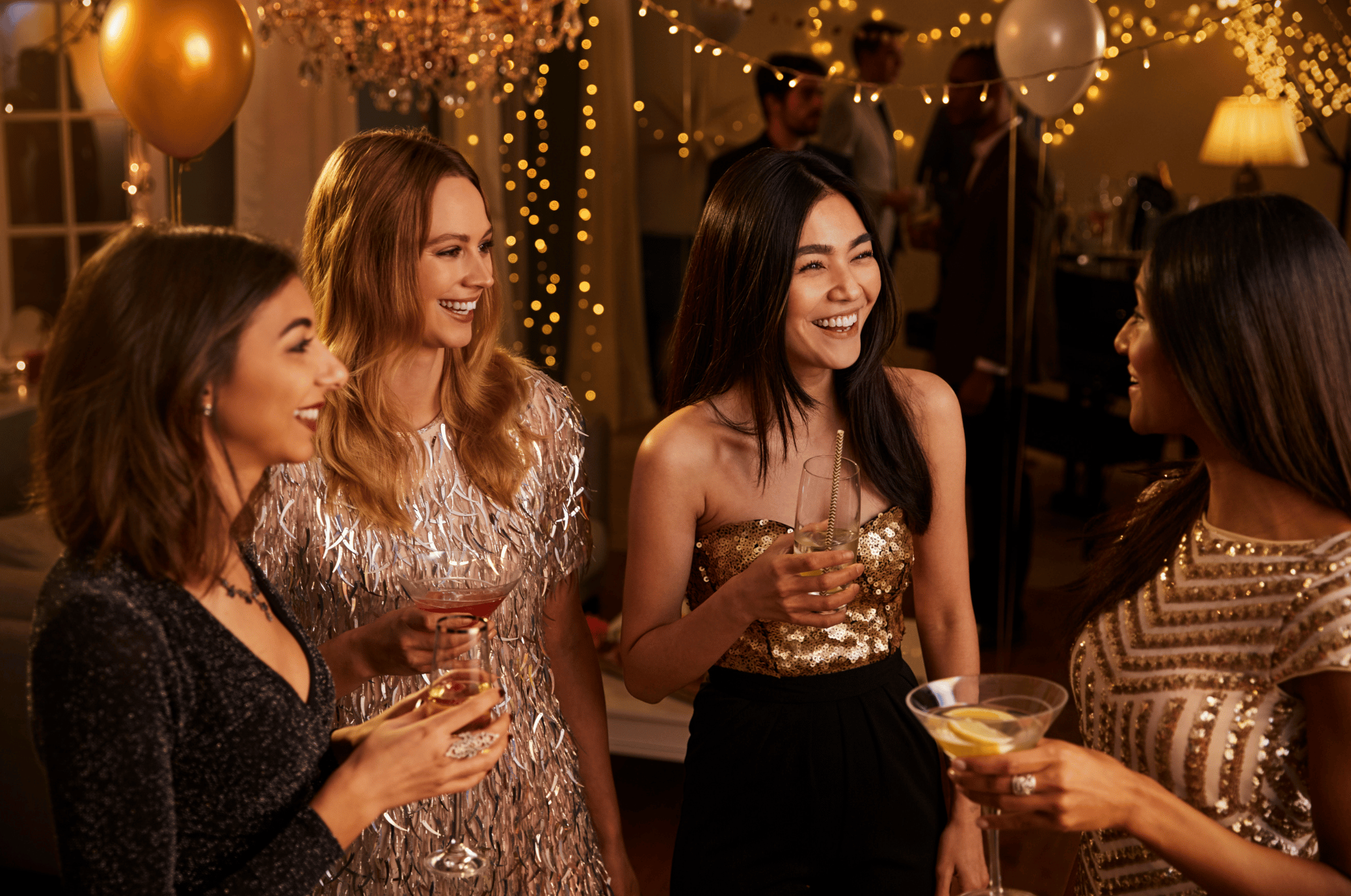 four women at a new year's eve party drinking champagne and talking
