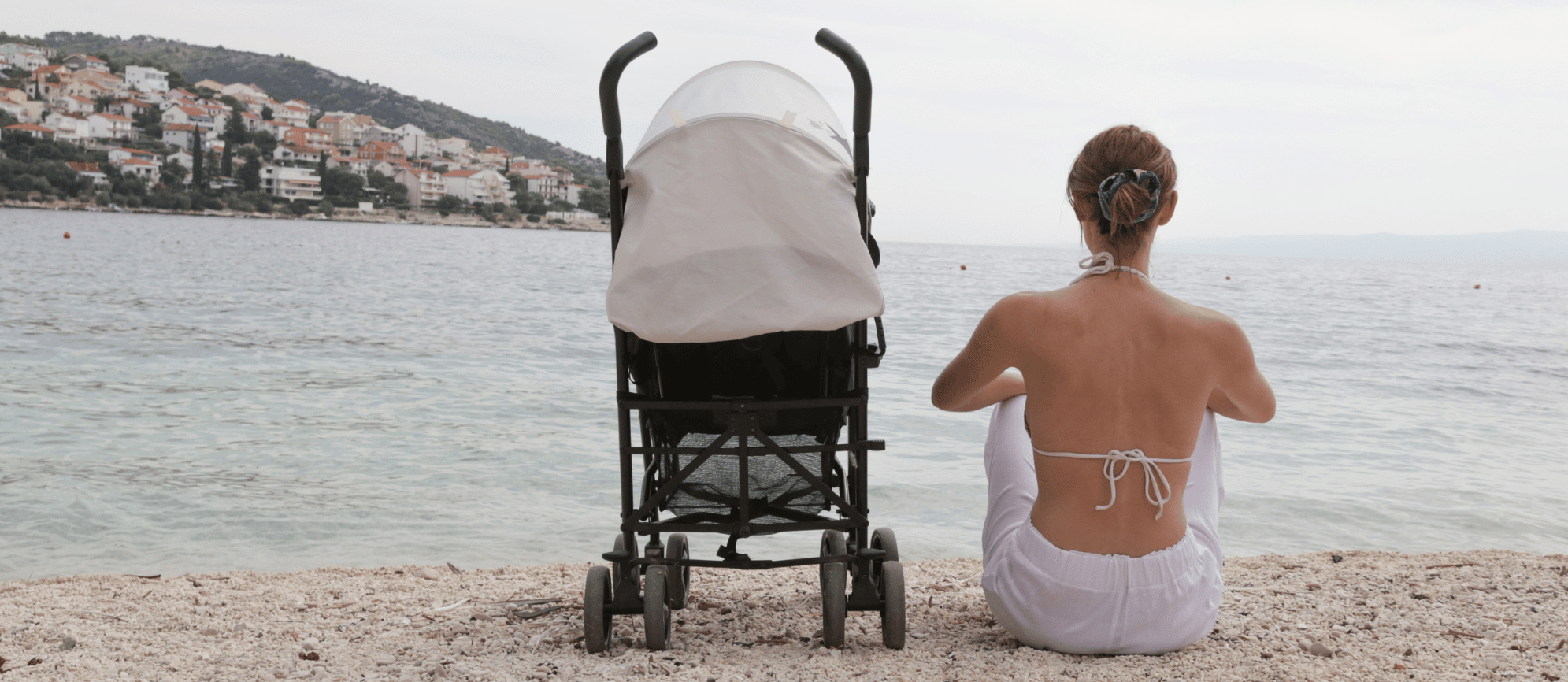 woman sitting with a stroller on the beach
